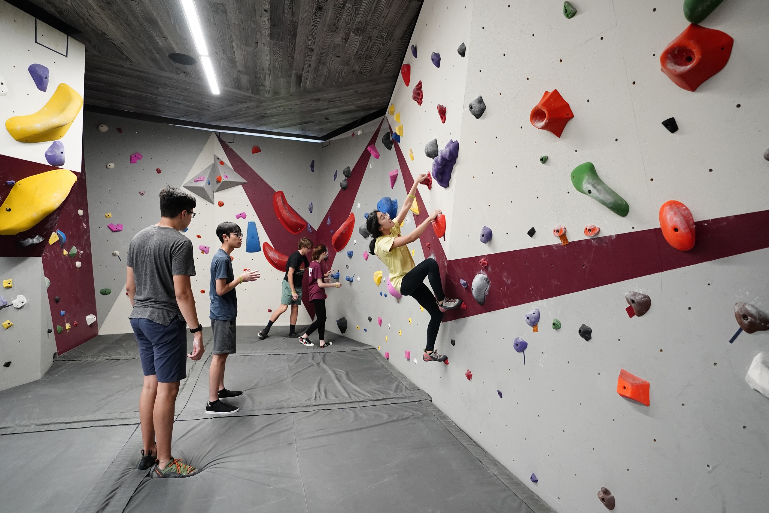 Members and guests doing free climbing on the bouldering wall in the Southside Rec Center
