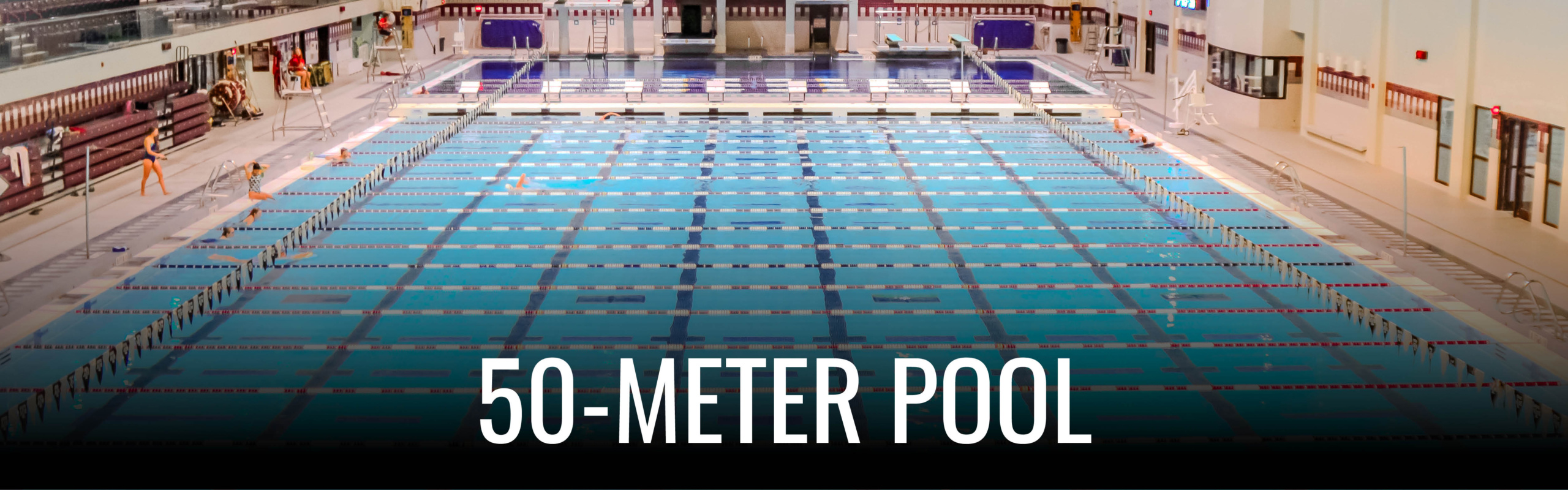 Indoor swimming pool at Texas A&M University, featuring multiple lanes and spectator seating.