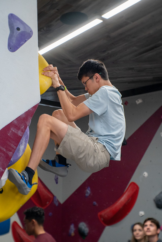 A student is climbing on the bouldering wall in the Southside Rec