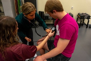 Personal Trainers are checking the blood pressure on one of their clients.