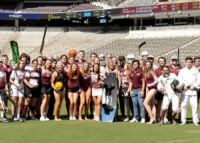 Large group of Texas A&M sport club athletes posing on Kyle Field with sports equipment representing various clubs.