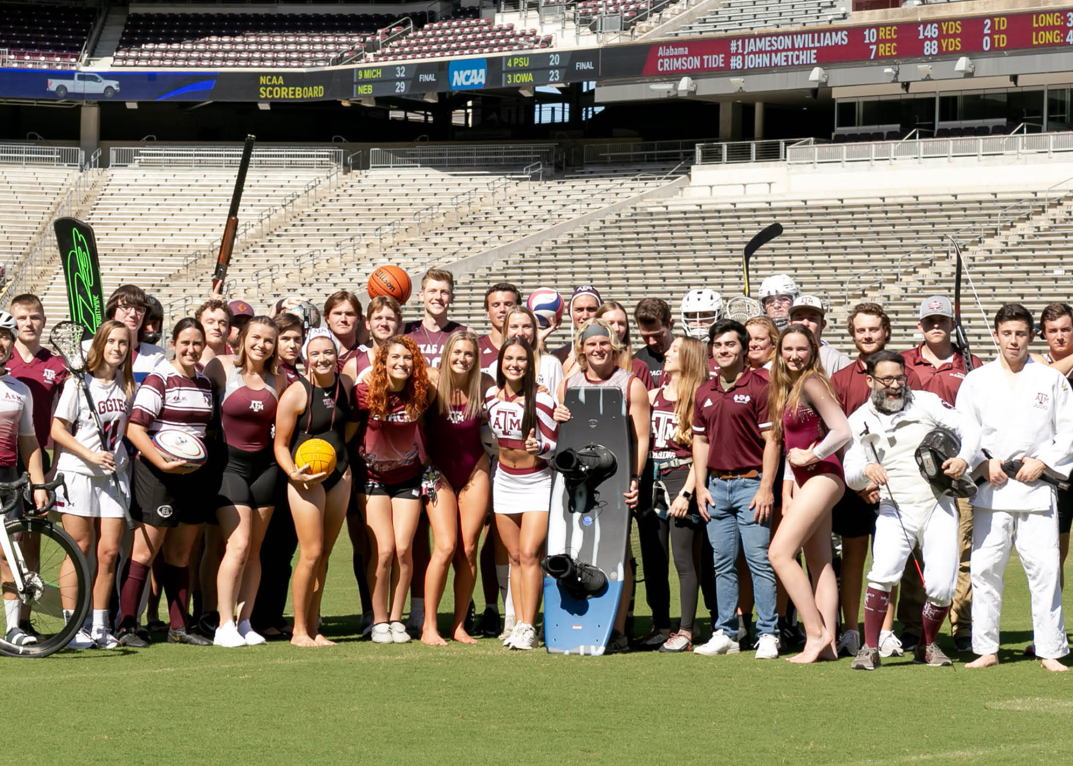 Large group of Texas A&M sport club athletes posing on Kyle Field with sports equipment representing various clubs.