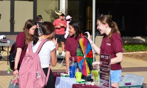 Students standing in front of the 12th man technology table and spinning the prize wheel at the Destress Fest.