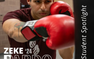 Zeke is standing in the boxing room in the student rec center with boxing gloves on punching a punching bag. His name Zeke Pardo '24 is written on top of the image.