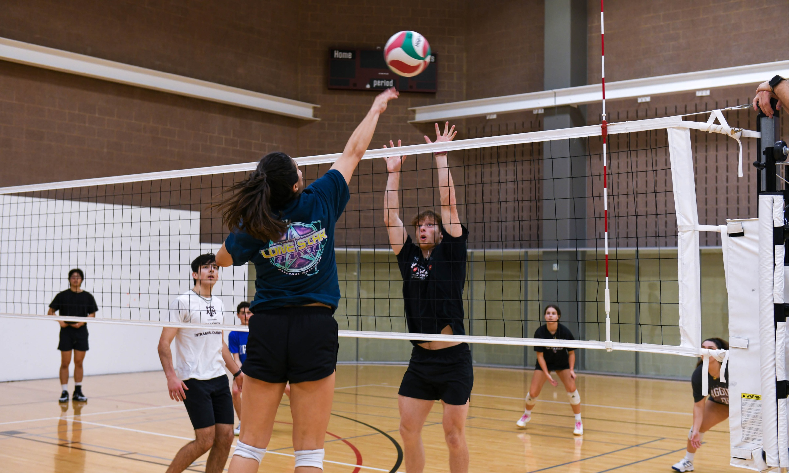 An athlete in action, extending their arm to make contact with the volleyball mid-air.