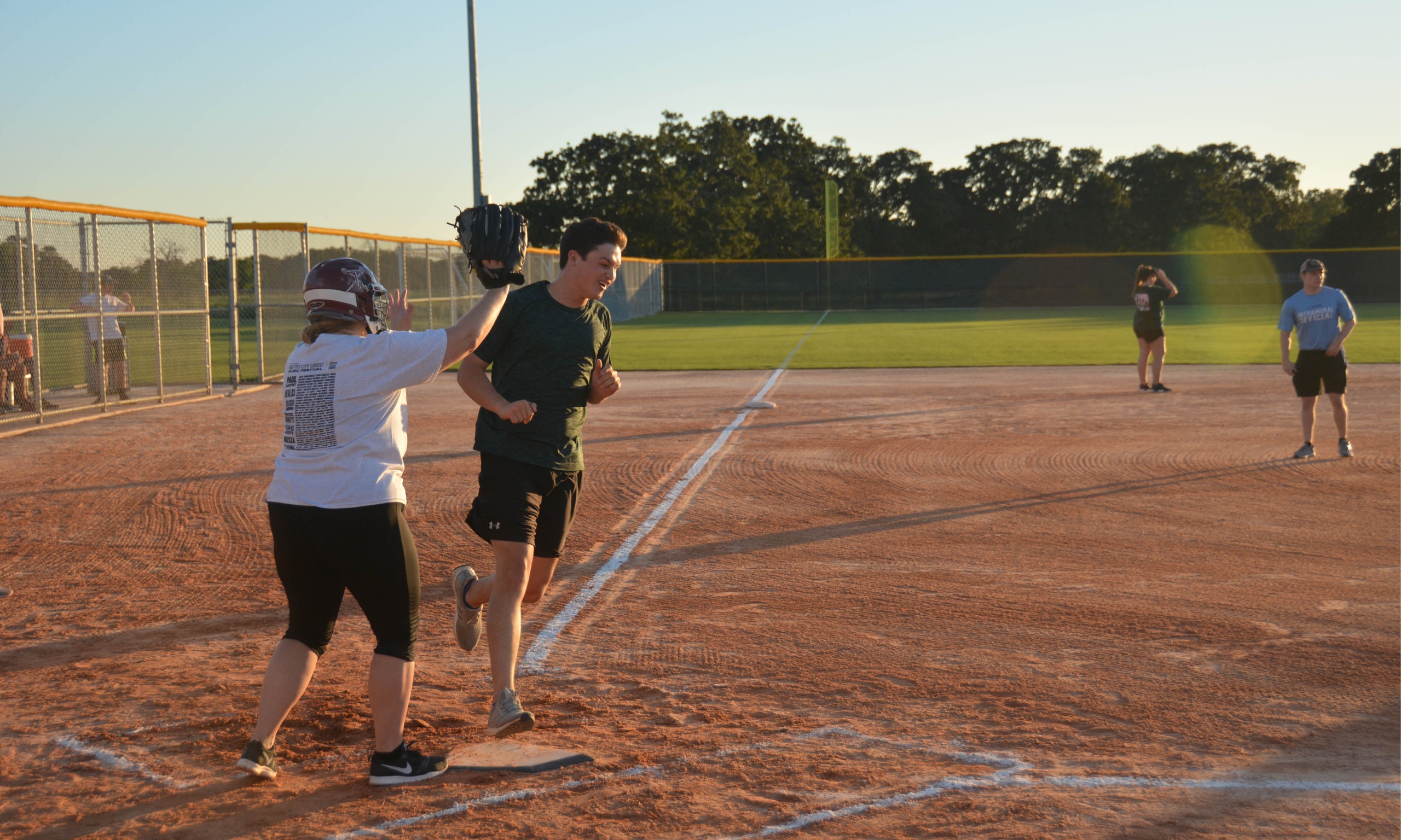Intramural slowpitch softball game in progress with players on the field.