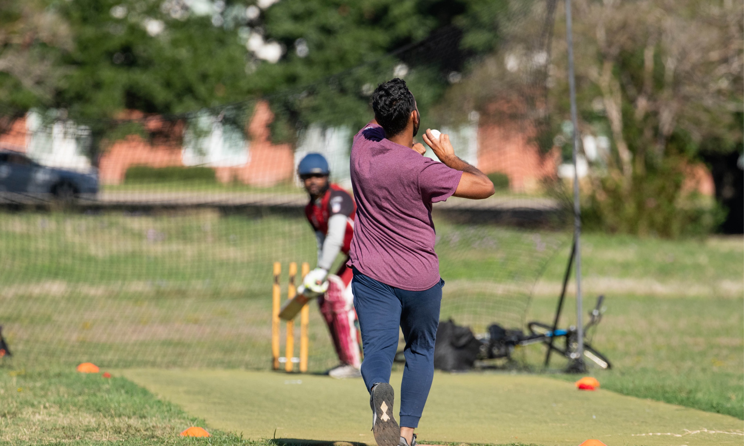 A man engaged in a game of cricket on a field, showcasing his skills and passion for the sport.