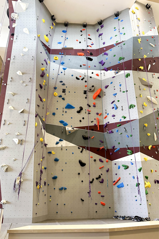 New Indoor Climbing Tower at Texas A&M Rec Sports featuring colorful climbing holds, maroon and gray wall design, and multiple top-rope routes.