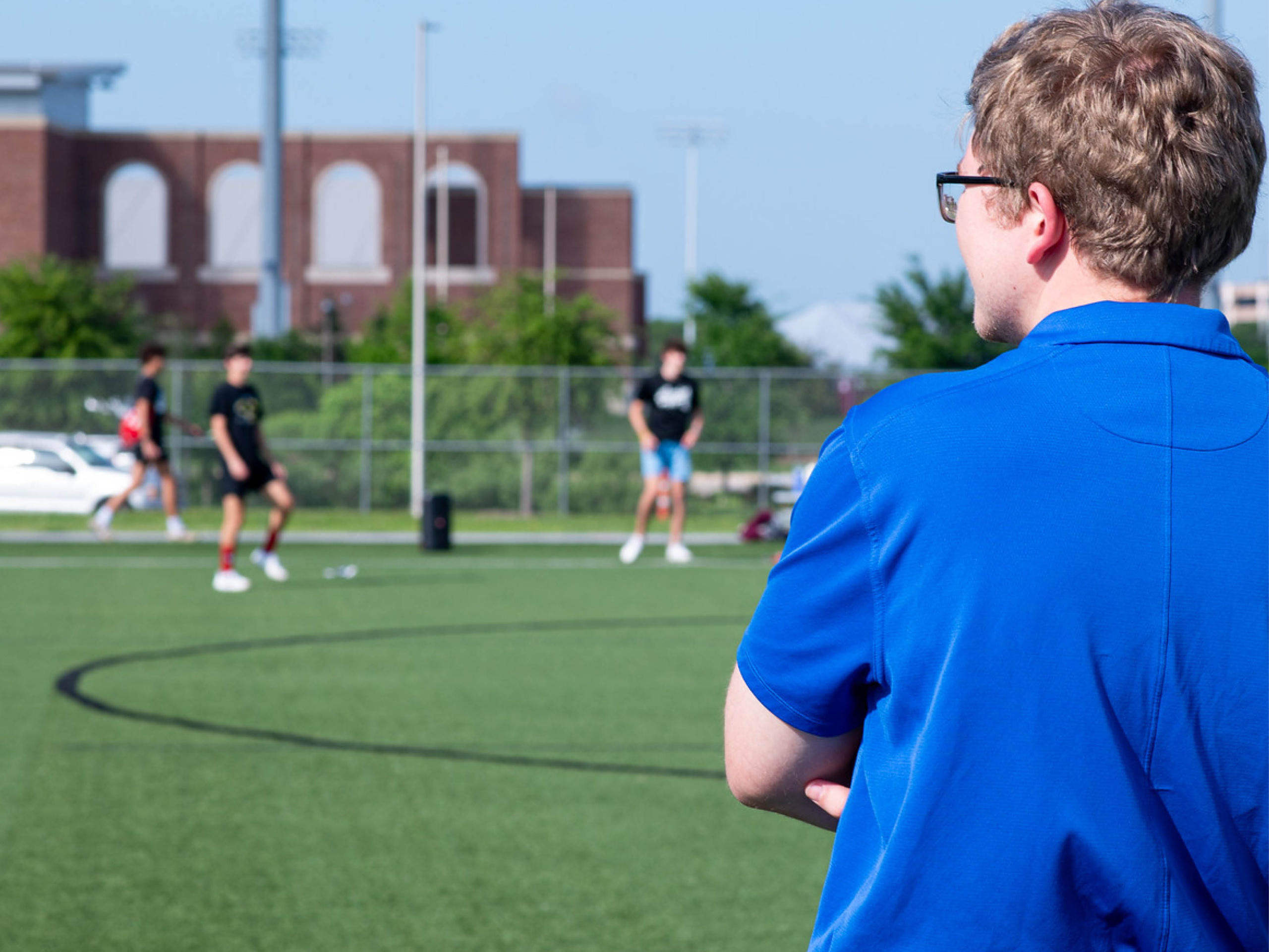 Colin is standing out on the soccer fields at the Penberthy Rec Sports complex while women's soccer is taking place in the background.