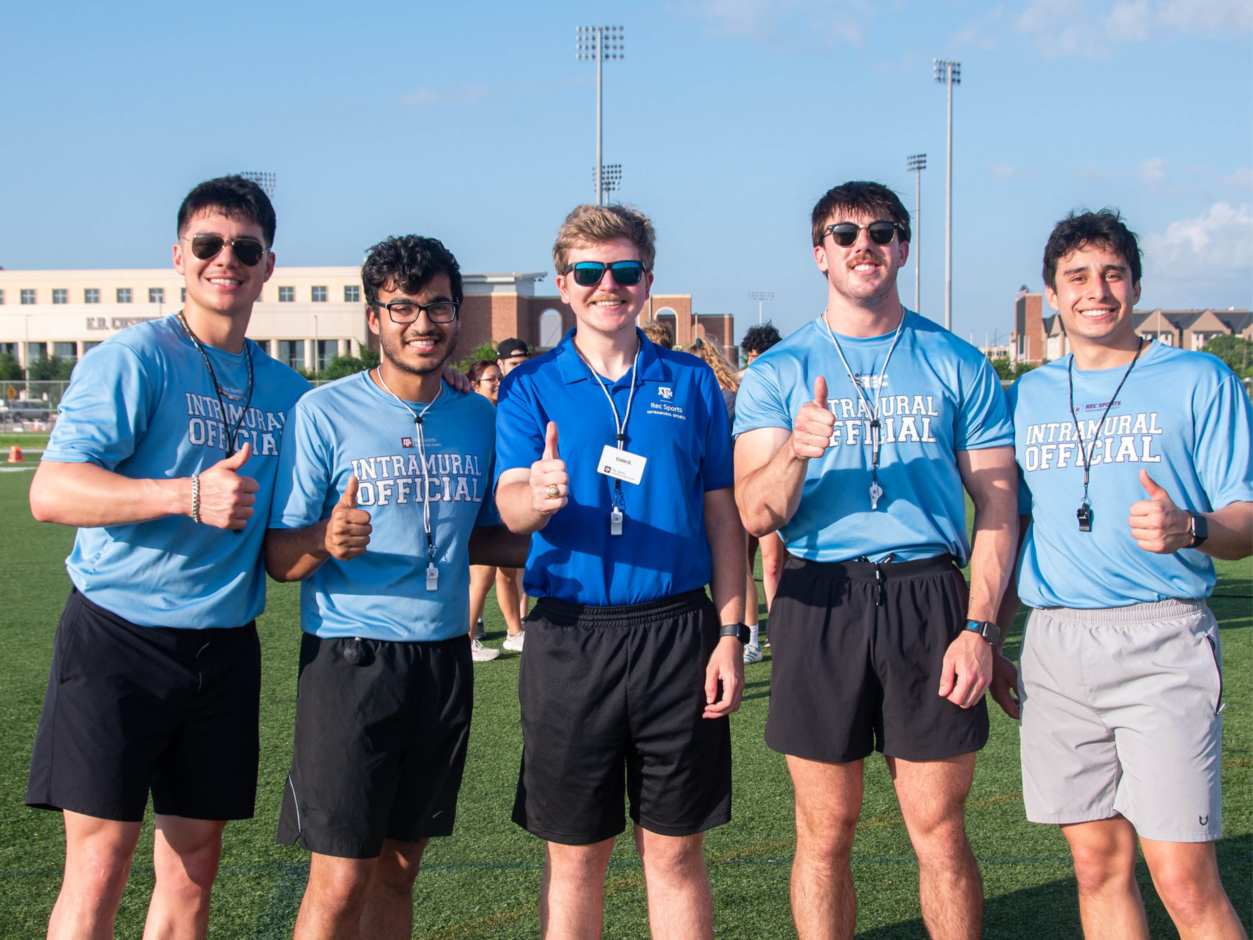 Colin Giusti is standing in the middle of 4 Rec Sports officials out on the penberthy fields. Each official is giving a thumbs up.