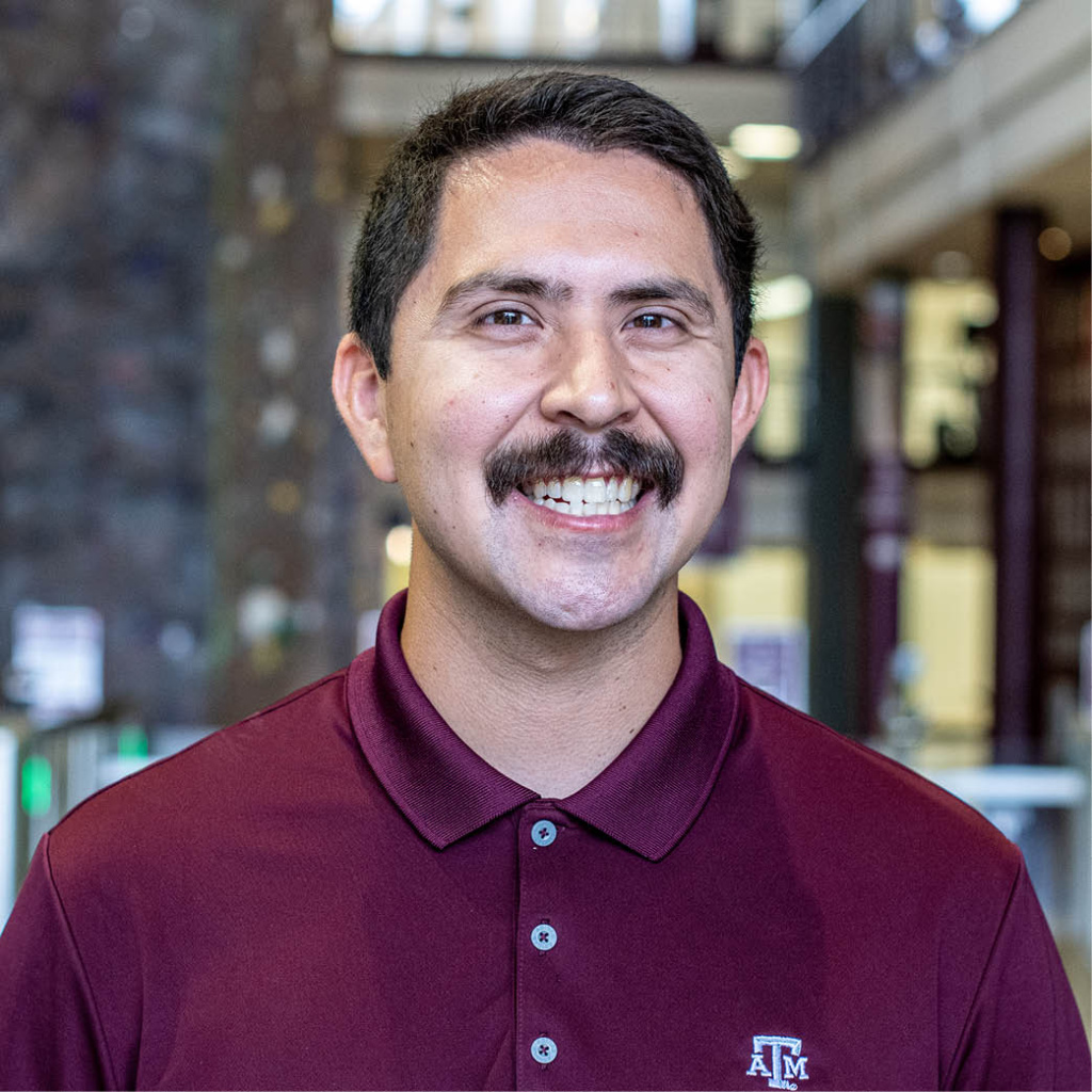 Portrait of Michael Gonzalez standing in front of the rockwall inside the student rec center.