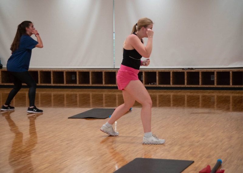 Instructor Payton Furtick and a participant in a fitness class at a studio doing a punch sequence.
