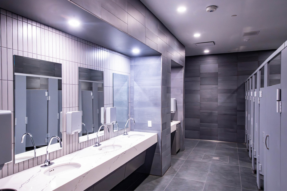 Women’s locker room vanity area at Texas A&M Rec Sports with marble countertops and modern lighting.