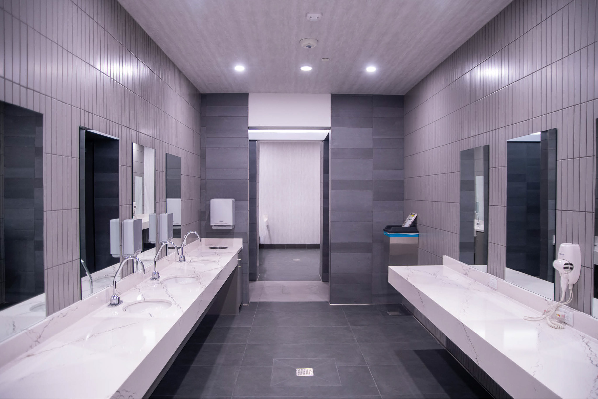 Women’s locker room vanity area at Texas A&M Rec Sports with marble countertops and modern lighting.