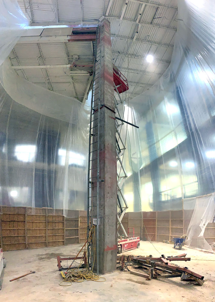 inside the construction of the indoor climbing facility displaying the center cement pillar that was holding the original wall.