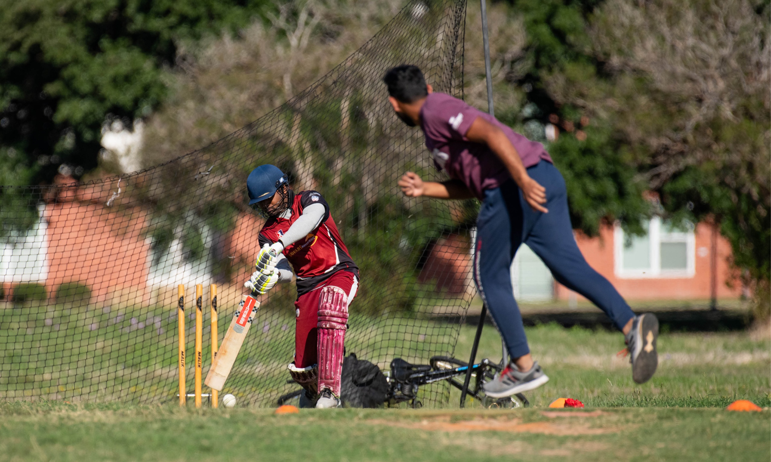 Men playing cricket at the fields at the Penberthy Rec Sports Complex.