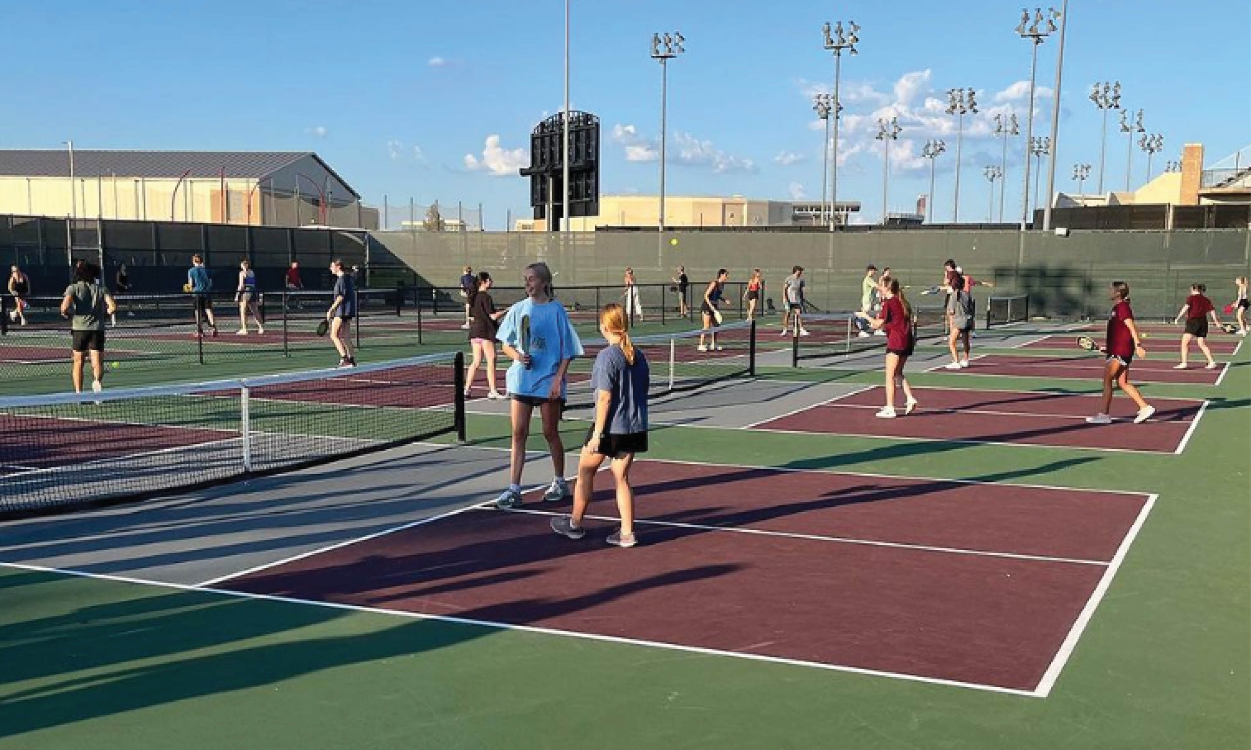 A group of individuals engaged in a game of pickleball on a court, showcasing their skills and enthusiasm