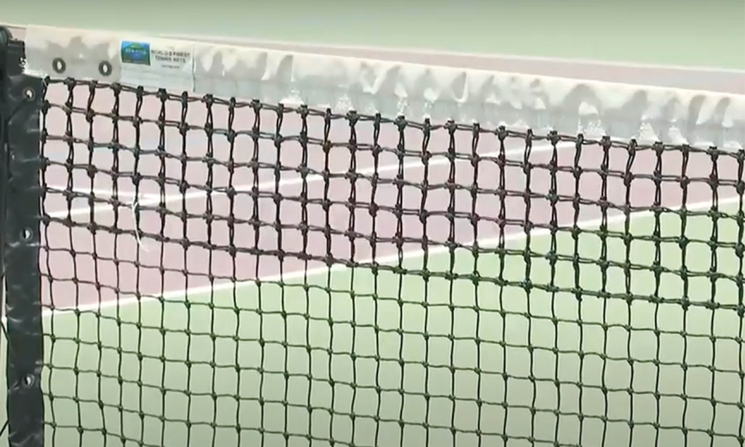 A tennis net with a white net stretched across it, providing a barrier for the players during a match.