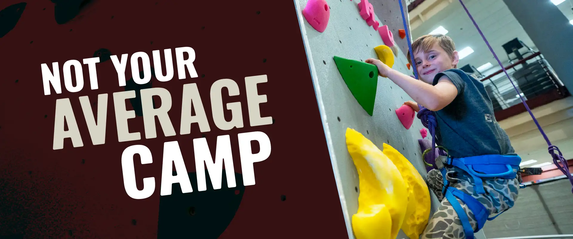 Child wearing a harness climbs a colorful indoor rock wall during Youth Programs camp, with “Not Your Average Camp” text displayed.